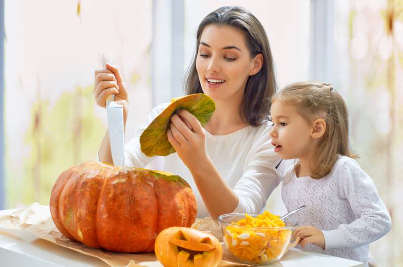 Military family mother and daughter carve a pumpkin together